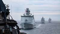 Drei graue Schiffe fahrenin Formation auf See